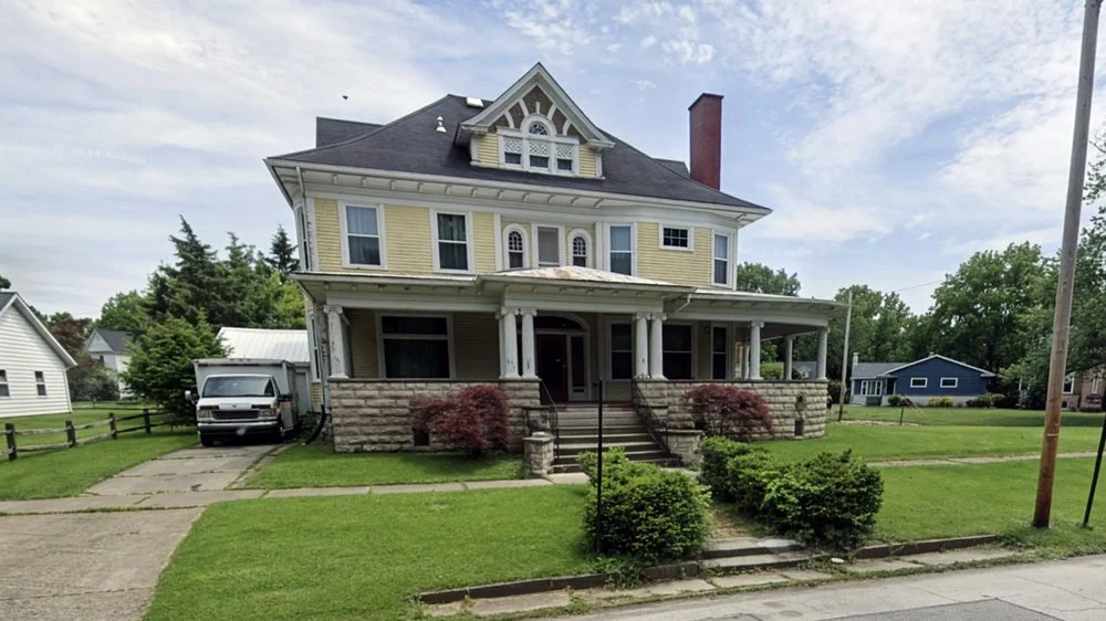 Historic Two-Story Yellow House with Wrap-Around Porch